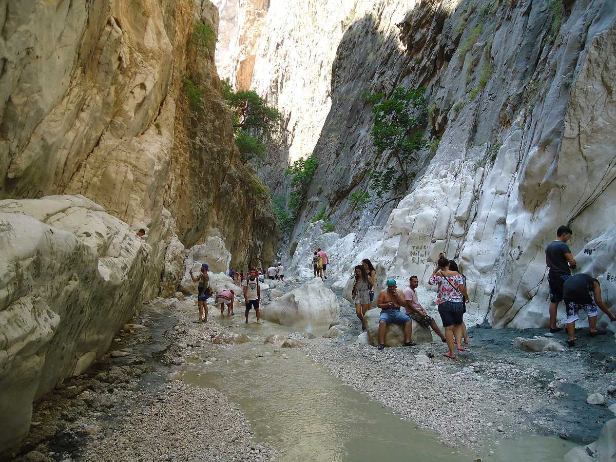 The narrow, deep interior of Saklıkent Gorge where visitors wade through the cold Eşen stream